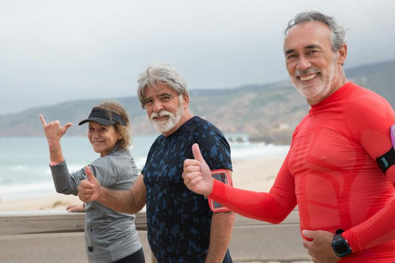 Three outdoor fitness enthusiasts giving a thumbs up
